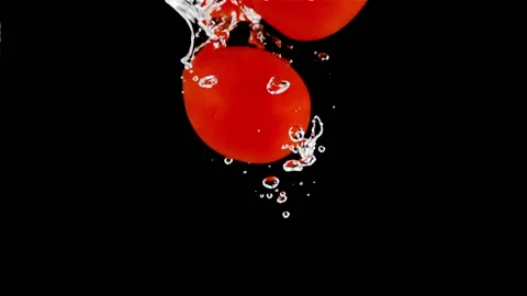 Super slow motion, a group of small tomatoes fall into the water Stock Footage 196667008