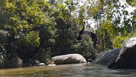 Super slow motion of a guy doing back flip from a rock. Stock Footage 115332265