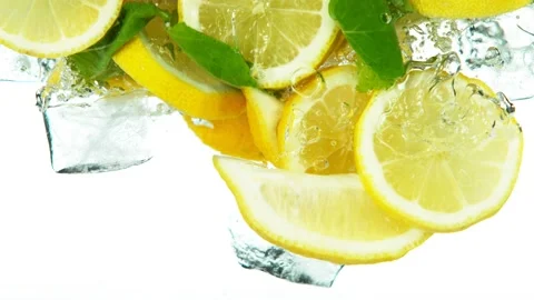 Super slow motion of lemon slices falling into water with ice cubes on white Vidéo 133721593