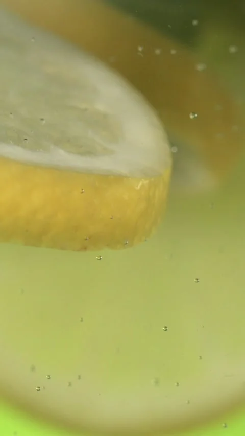Super Slow Motion Lemon Wedge Drifting In Liquid, Juicy Lemon Slice Gently Stock Footage 327095721