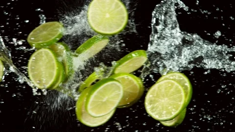 Super slow motion of lime pieces collision with water splashes, black background Stock Footage 132508834
