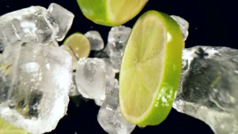 Super slow motion of lime slices falling with ice cubes on black background Stock Footage 149006090