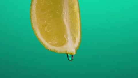 Super Slow Motion Macro Shot of Water Drop Falling from Lemon Slice on Blue Stock Footage 201170659
