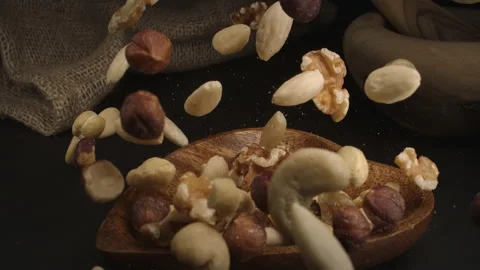 Super slow motion of Mix nuts falling with wood bowl. 4k at 1000fps. Stock Footage 159553262