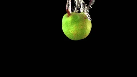 Super slow motion one green pear falls under the water with air bubbles. Filmed Stock Footage 154489134