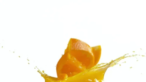 Super slow motion of orange slices falling into juice on white Stock Footage 128656694