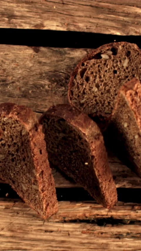 Super slow motion pieces of fresh bread fall on the table. Filmed on a high Stock Footage 335287540