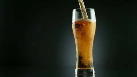 Super slow motion of pouring beer drink into glass, placed on black background Stock Footage 125284531