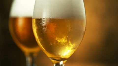 Super slow motion of pouring beer into glass, golden background. Stock Footage 237165368