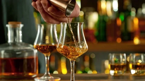 Super slow motion of pouring cognac into glass with speed motion Stock Footage 231305048