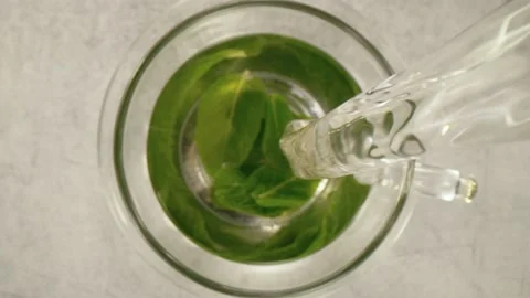 Super slow motion of pouring mint tea into cup with camera follow Stock Footage 148694145