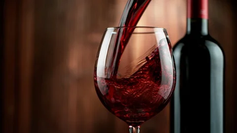 Super slow motion of pouring red wine with wooden background Stock Footage 120758126