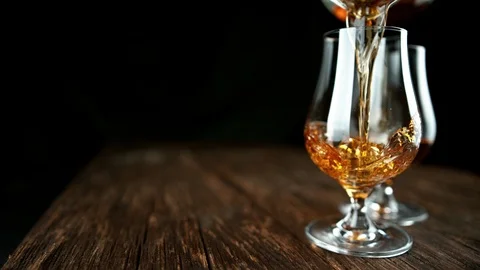 Super slow motion of pouring rum or cognac into glass Stock Footage 121312136