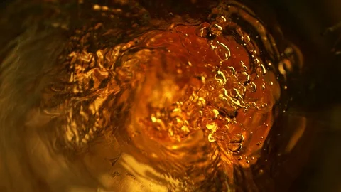 Super slow motion of pouring whiskey, rum or ice tea, inside bottle view. Stock Footage
