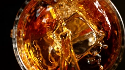Super slow motion of pouring whiskey into glass, top view shot. Stock Footage 165018063