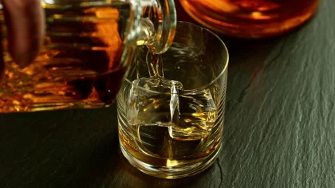 Super slow motion of pouring whiskey into glass. Stock Footage 233250859