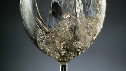 Super slow motion of pouring white wine into glass, speed ramp effect. Stock Footage 155417519