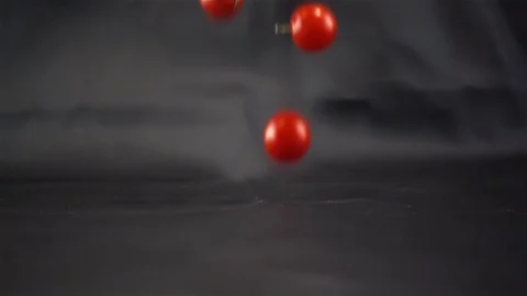 Super Slow Motion of Red Fresh Tomatos Falling on Black Surface Stock Footage 82209158