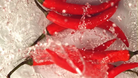 Super slow motion red hot chili pepper falls into the water with splashes.Filmed Stock Footage 155326765