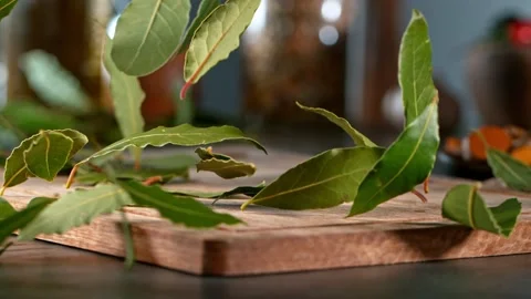 Super slow motion of rolling bay leaves on wooden board. Stock Footage 166967427