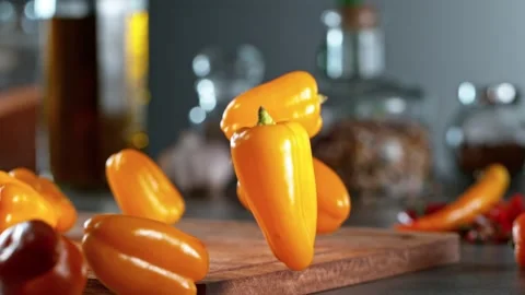Super slow motion of rolling chilli peppers on wooden board. Stock Footage 166963152