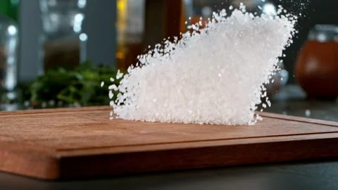 Super slow motion of rolling coarse-grained salt on wooden board. Stock Footage 166962489