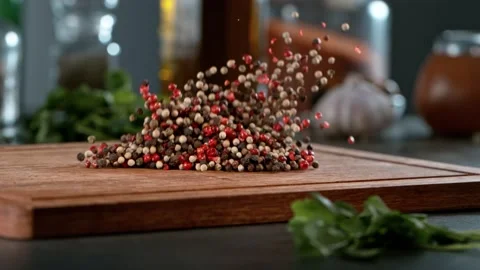 Super slow motion of rolling pepper spice on wooden board. Stock Footage 166962522