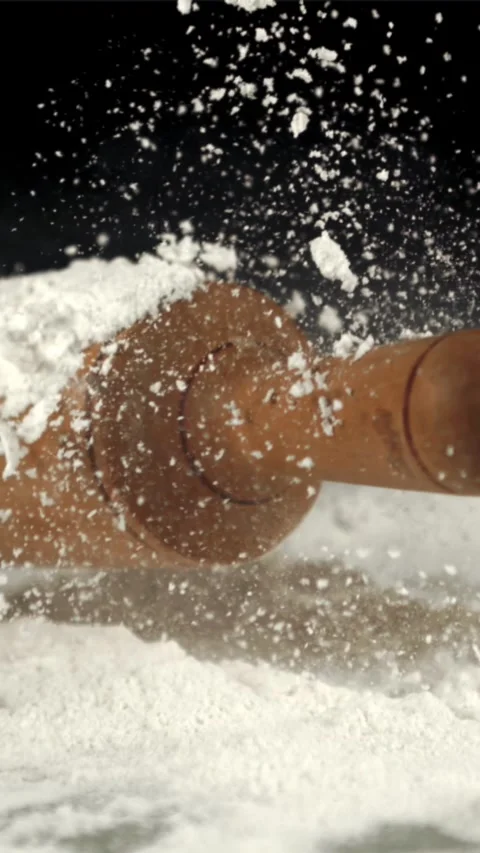 Super slow motion of the rolling pin falls on the table with flour. Filmed on a Stock Footage 335287637