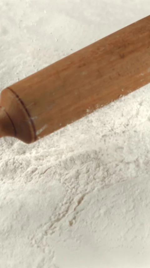 Super slow motion of the rolling pin falls on the table with flour. Filmed on a Stock Footage 335287796