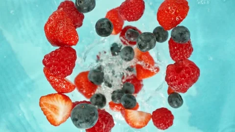 Super slow motion of rotating berries falling into water. Stock Footage 280253719