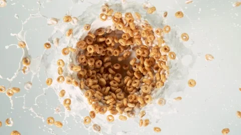 Super slow motion of rotating cereal pieces with milk splashes on white. Stock Footage 134814954