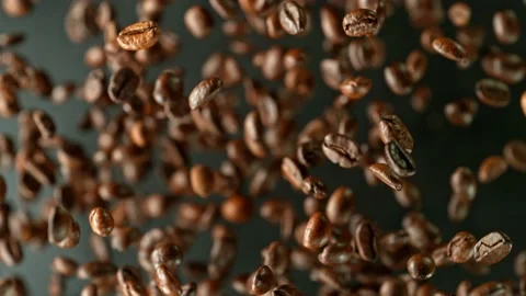 Super slow motion of rotating coffee beans on black background. Stock Footage 227312212