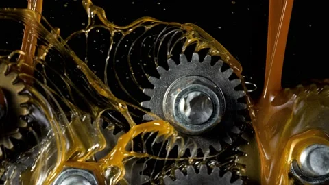Super slow motion of rotating engine steel wheels with oil splashes Stock Footage 142437448