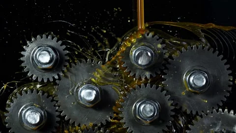 Super slow motion of rotating engine steel wheels with oil splashes Stock Footage 142442042