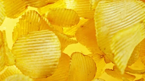 Super slow motion of rotating fried potatoes chips on yellow background Stock Footage 238439869