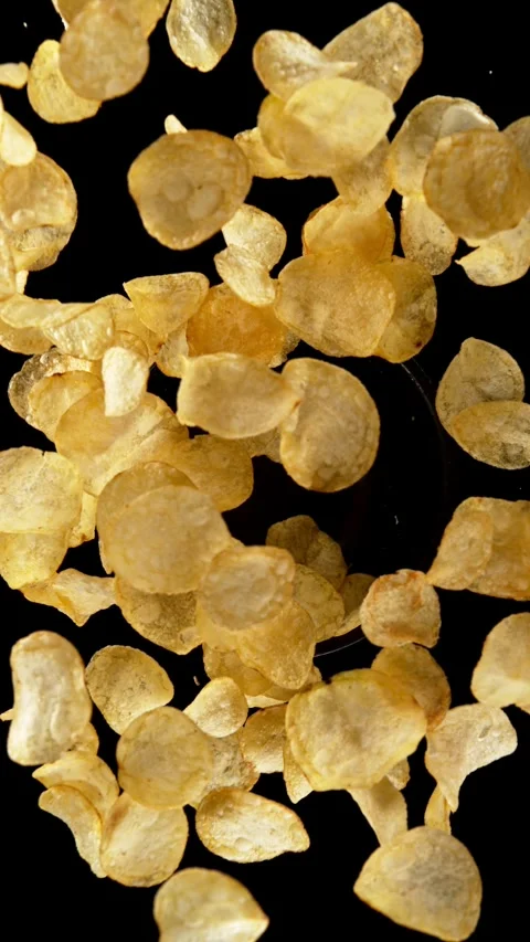 Super slow motion of rotating fried potatoes chips on black background. Stock Footage 306576345