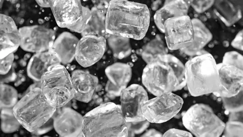 Super slow motion of rotating ice cubes, top view shot. Stock Footage 239428784