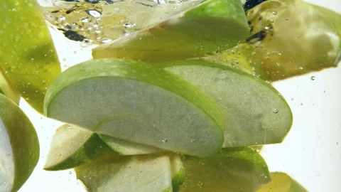 Super slow motion of rotating sliced green apples pieces underwater Stock Footage 193192599