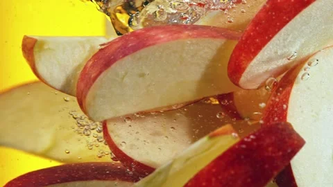 Super slow motion of rotating sliced red apples pieces underwater Stock Footage 193320648