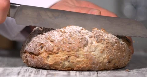 Super slow motion, Rustic Bread Cut With Flourish. Warm Studio Scene With Chef C Stock Footage 331720796