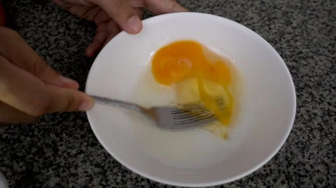 Super slow motion of scrambling eggs in a bowl with fork Stock Footage 64231672