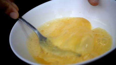 Super slow motion of scrambling eggs in a bowl with fork Stock Footage 64231859