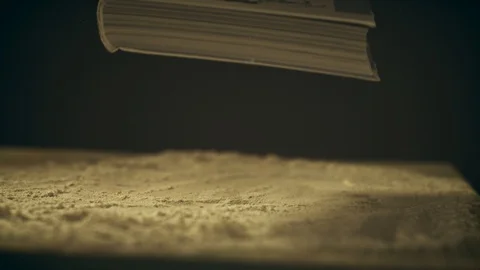 Super slow motion shot of a book falling down on a dusty wooden table, close-up Stock Footage 120234476