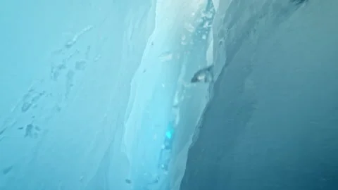 Super Slow Motion SHot of Camera Passing Through Glacier Ice Crack With Falling Stock Footage 341230853