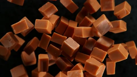 Super Slow Motion Shot of Caramel Pieces Exploded Towards Camera Isolated on Stock Footage 211131377