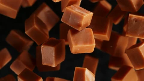 Super Slow Motion Shot of Caramel Pieces Exploded Towards Camera Isolated on Video stock 220832063