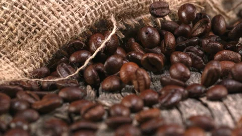 Super slow motion shot. Coffee beans fall on an old oak table at 1000fps. Stock Footage 167474032