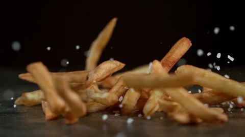 Super Slow Motion Shot of Falling Fresh French Fries on Black Table and Adding Stock Footage