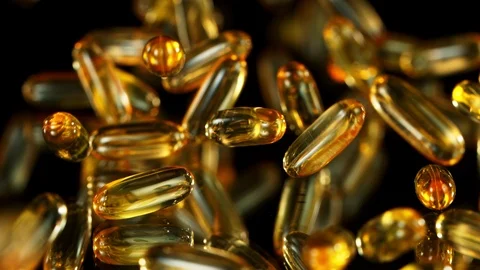 Super Slow Motion Shot of Falling Omega 3 Fish Oil Capsules on Black Background 123895733