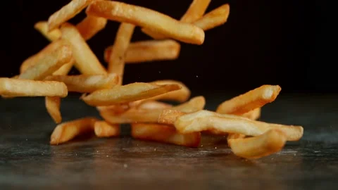 Super Slow Motion Shot of Falling Fresh French Fries on Wooden Table Stock Footage 136596323